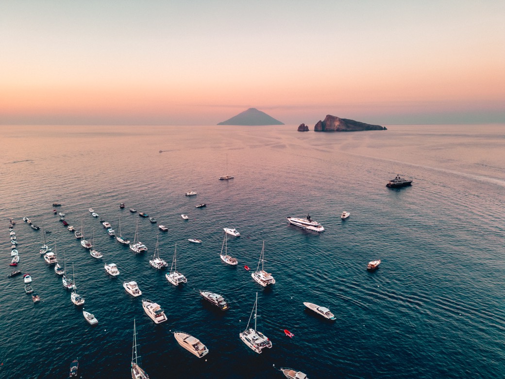 The Yacht Week fleet moored off the Aeolian islands at sunset